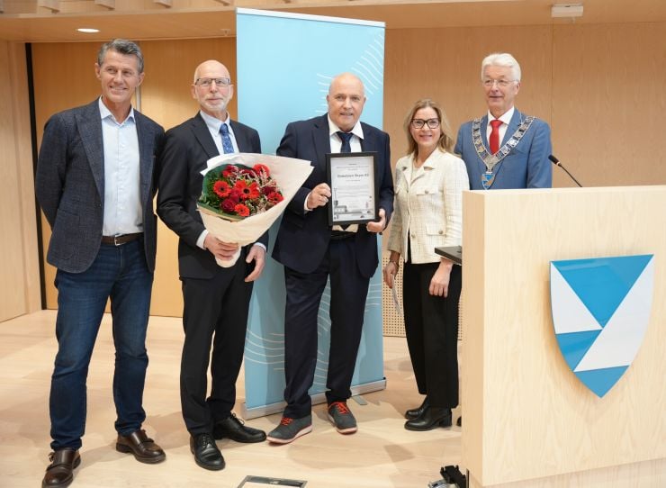 utdeling av bedriftsutviklingsprisen, bilde av dei som delte ut prisen og dei som fekk prisen med blomster og diplom.