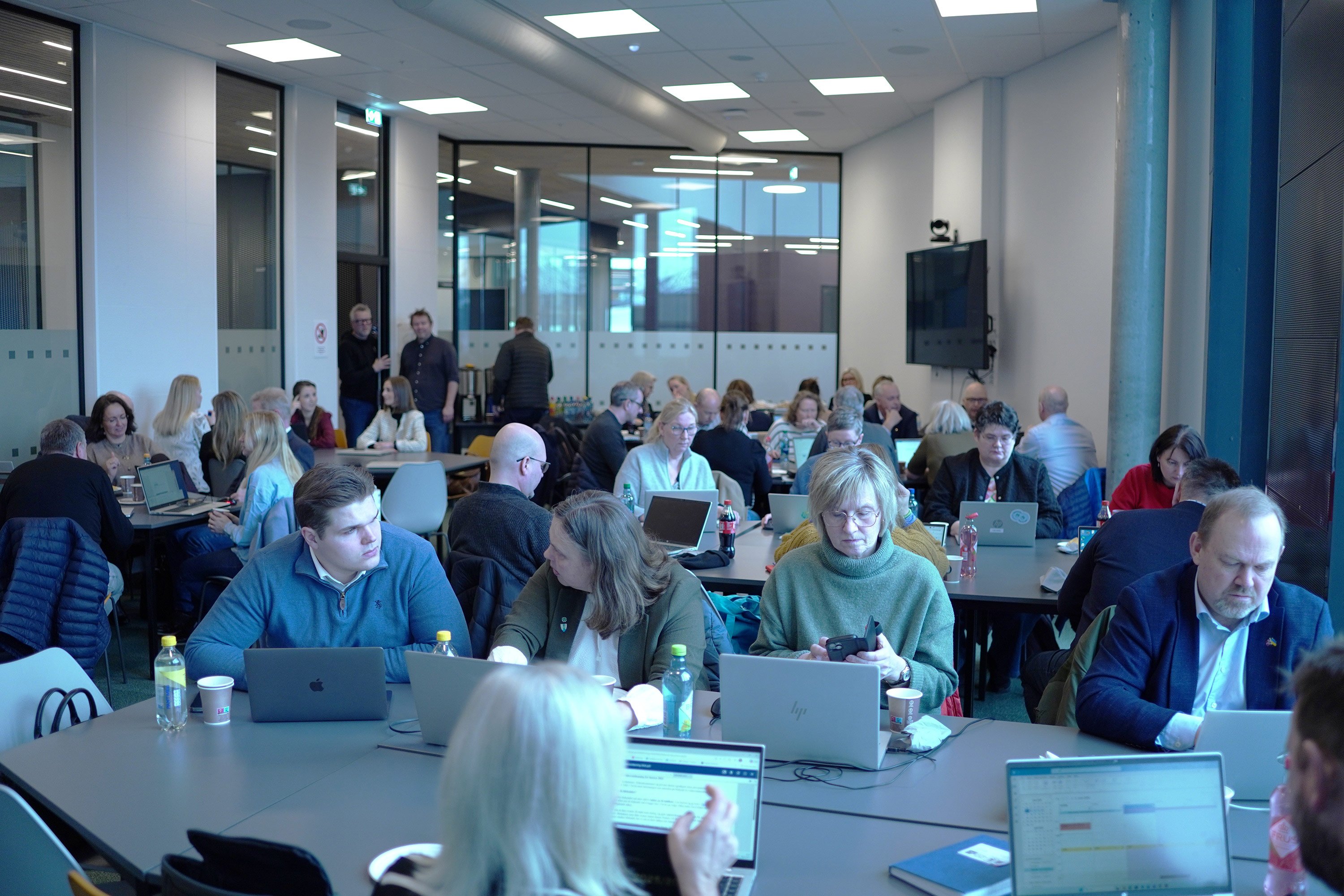 Deltakarar på kurset som jobbar på laptopar og snakkar saman.