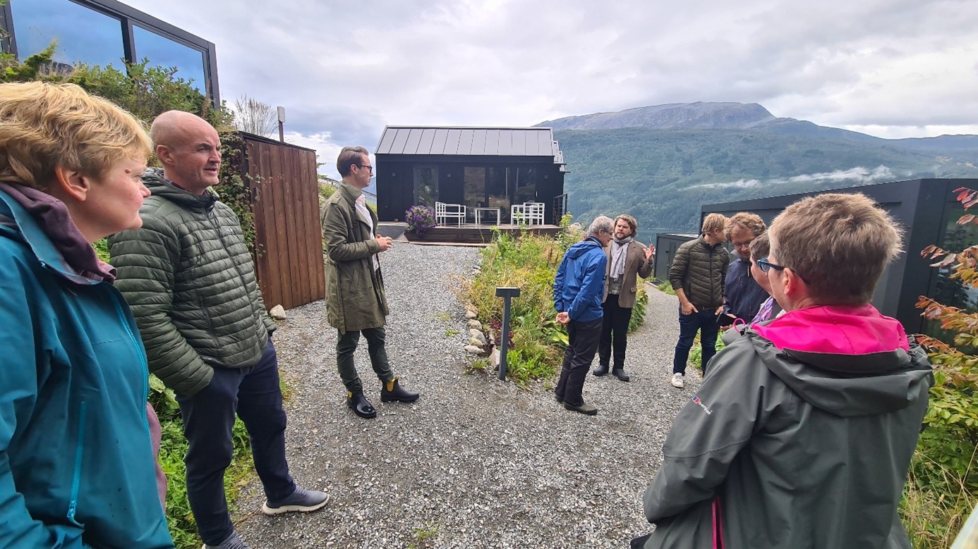 Bygninger og landskap , med mennesker i forgrunnen