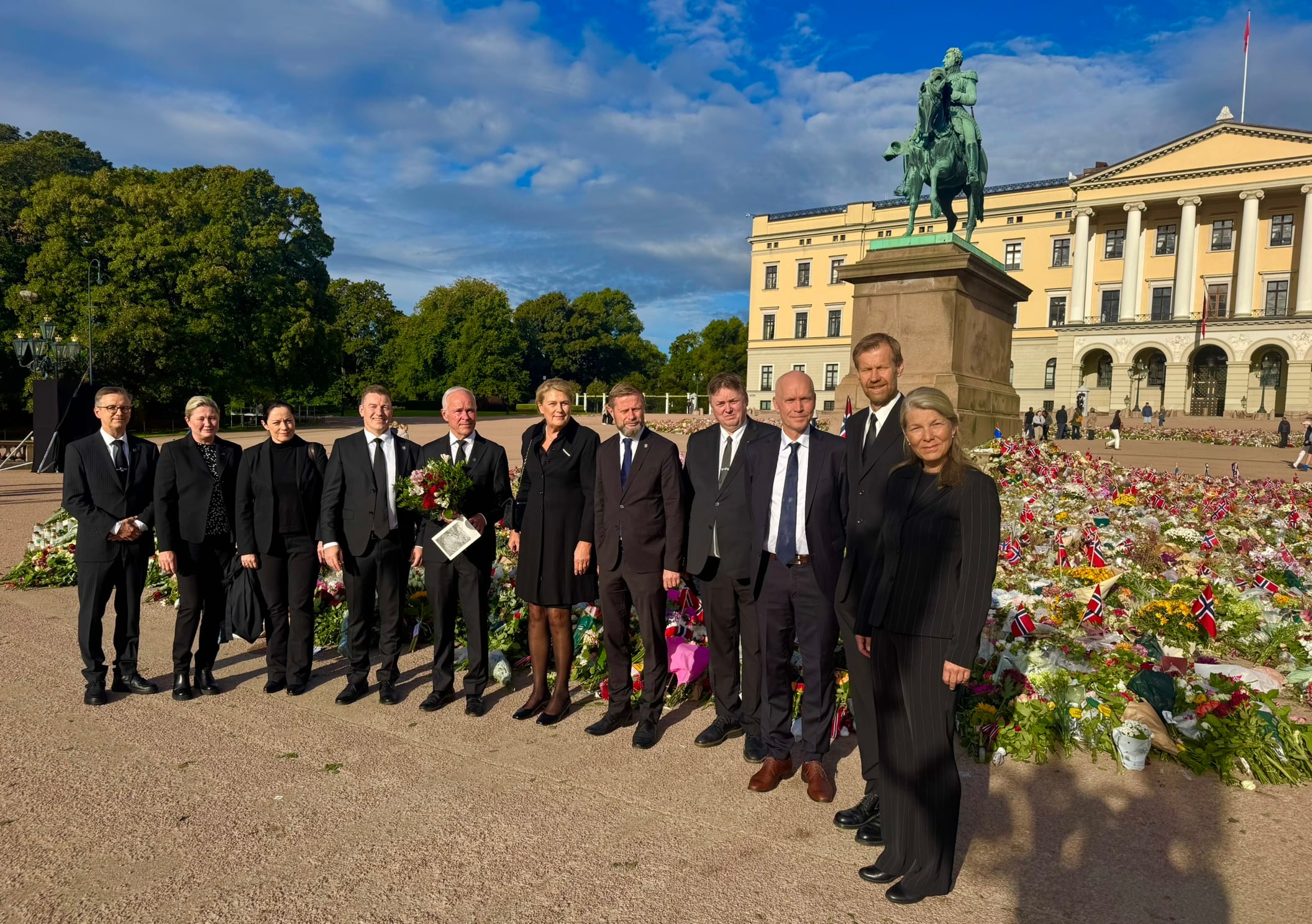 Statsforvalterne og Sysselmesteren på Svalbard står samlet ved blomsterhavet på Slottsplassen foran Slottet i Oslo før defileringen ved Kong Harald Vs båre i Slottskapellet.