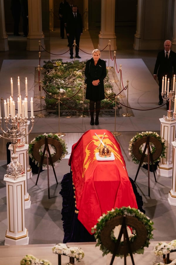 Statsforvalter Gina Lund under defileringen ved Kong Harald Vs båre i Slottskapellet. Båren er omgitt av lys og kranser under den nasjonale markeringen i forbindelse med gravferden.