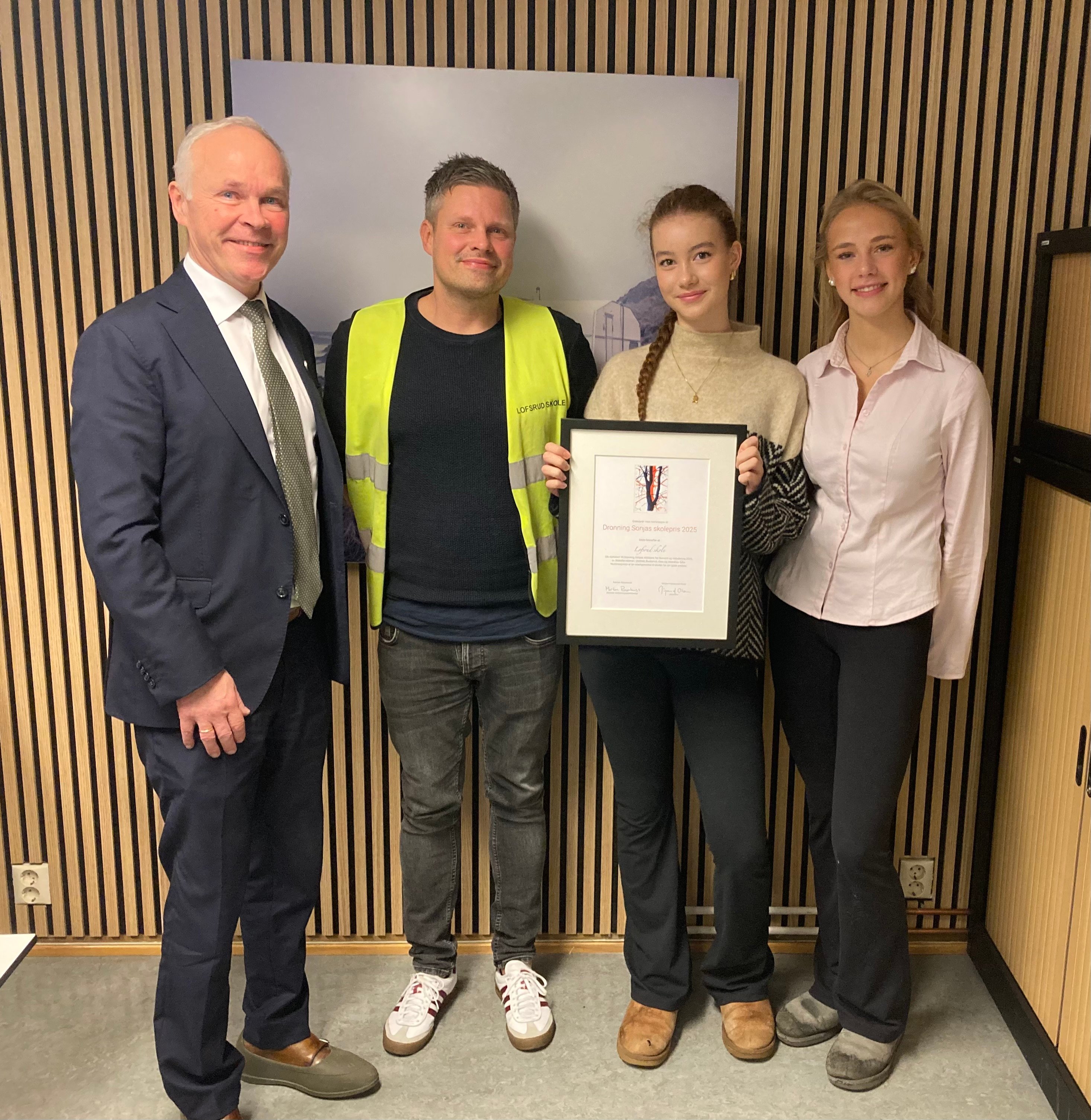 Statsforvalter Jan Tore Sanner deler ut diplomet til rektor Trond Nilsen og Emma Marie Bretting Øvrebø og Sunniva Johannessen Buckley fra elevrådet.