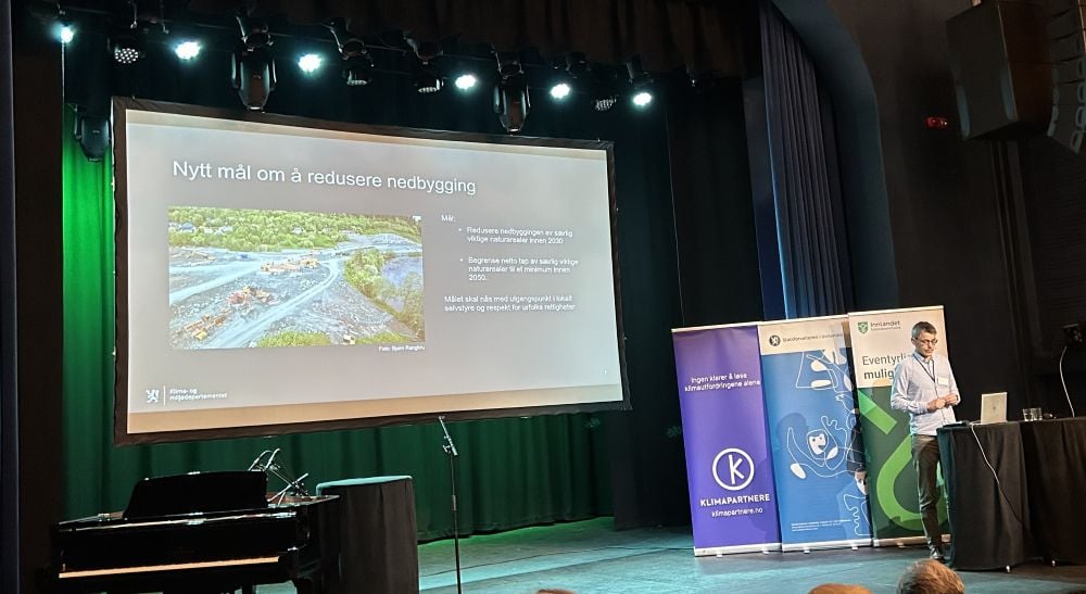 Mann på scene som holder en presentasjon