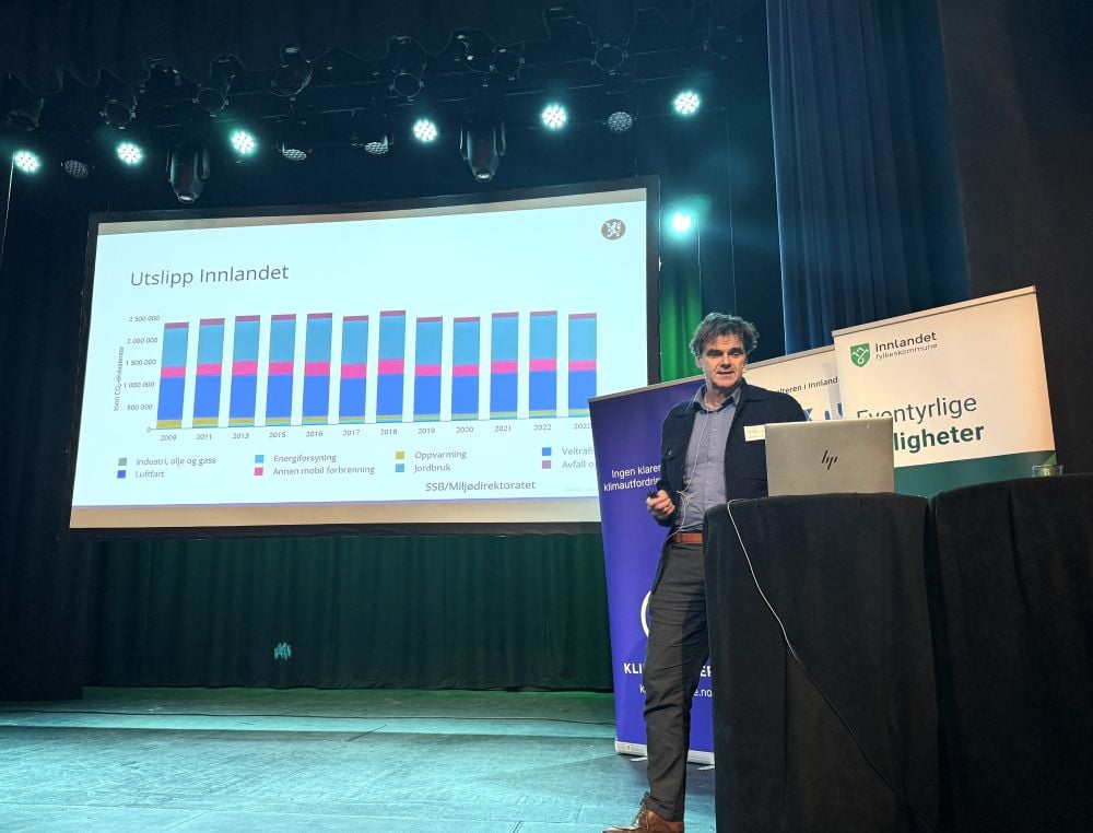 Mann står på en scene og holder en presentasjon