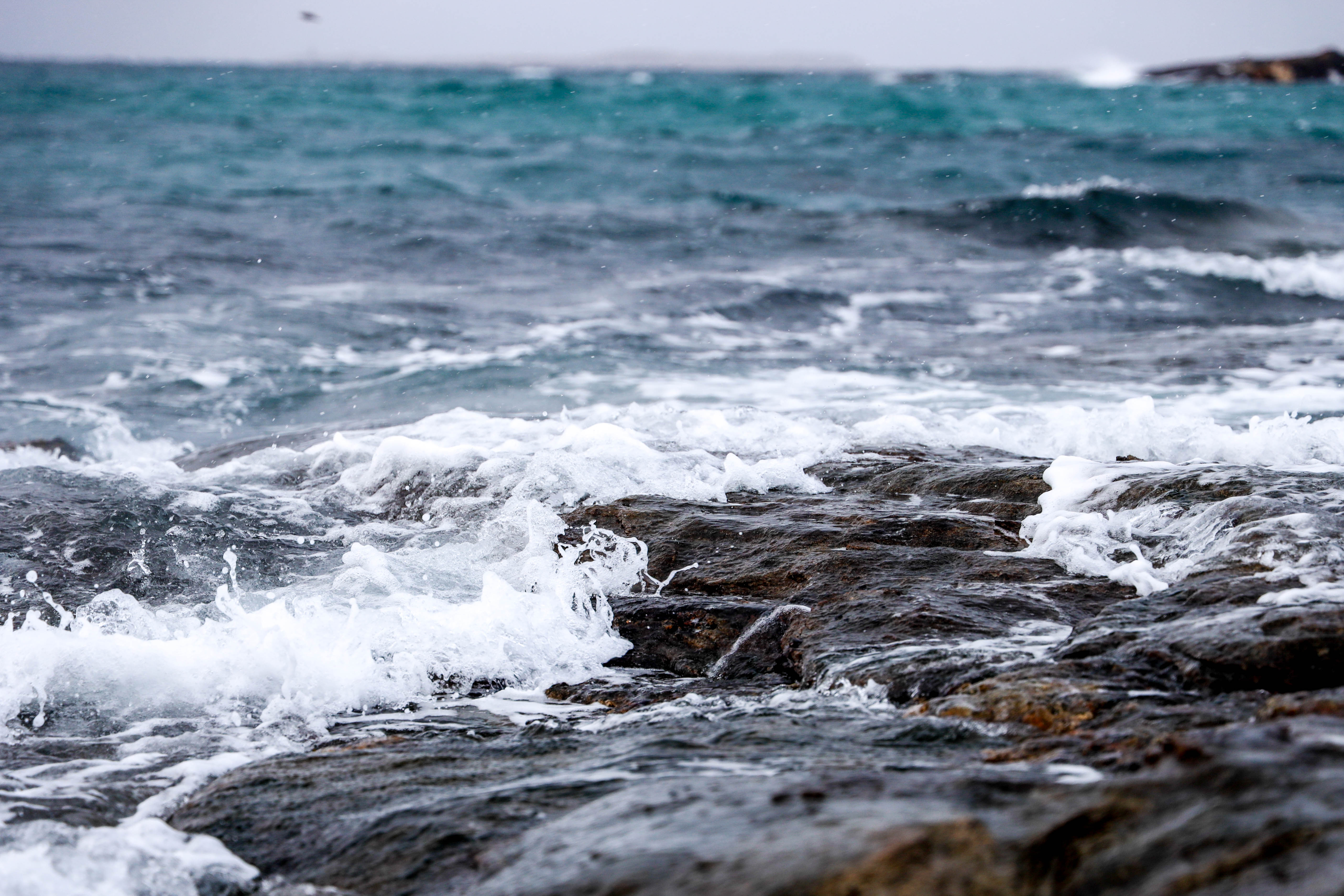 Bølger skyller innover et berg. 