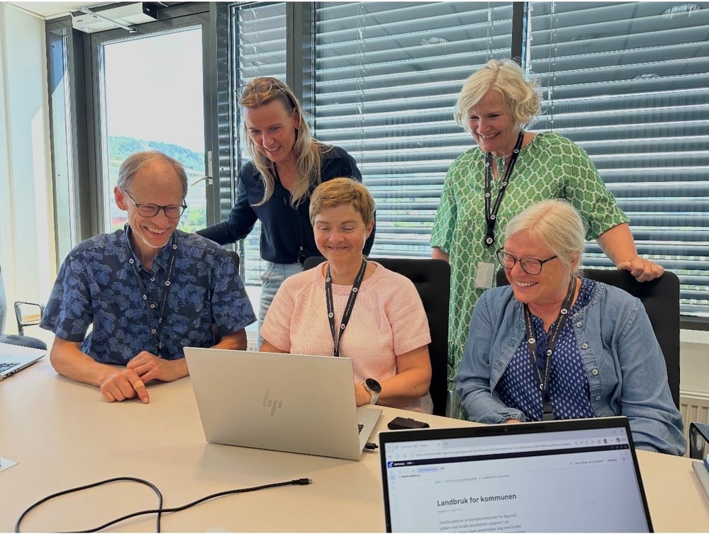 Folk ser på pc i et møterom