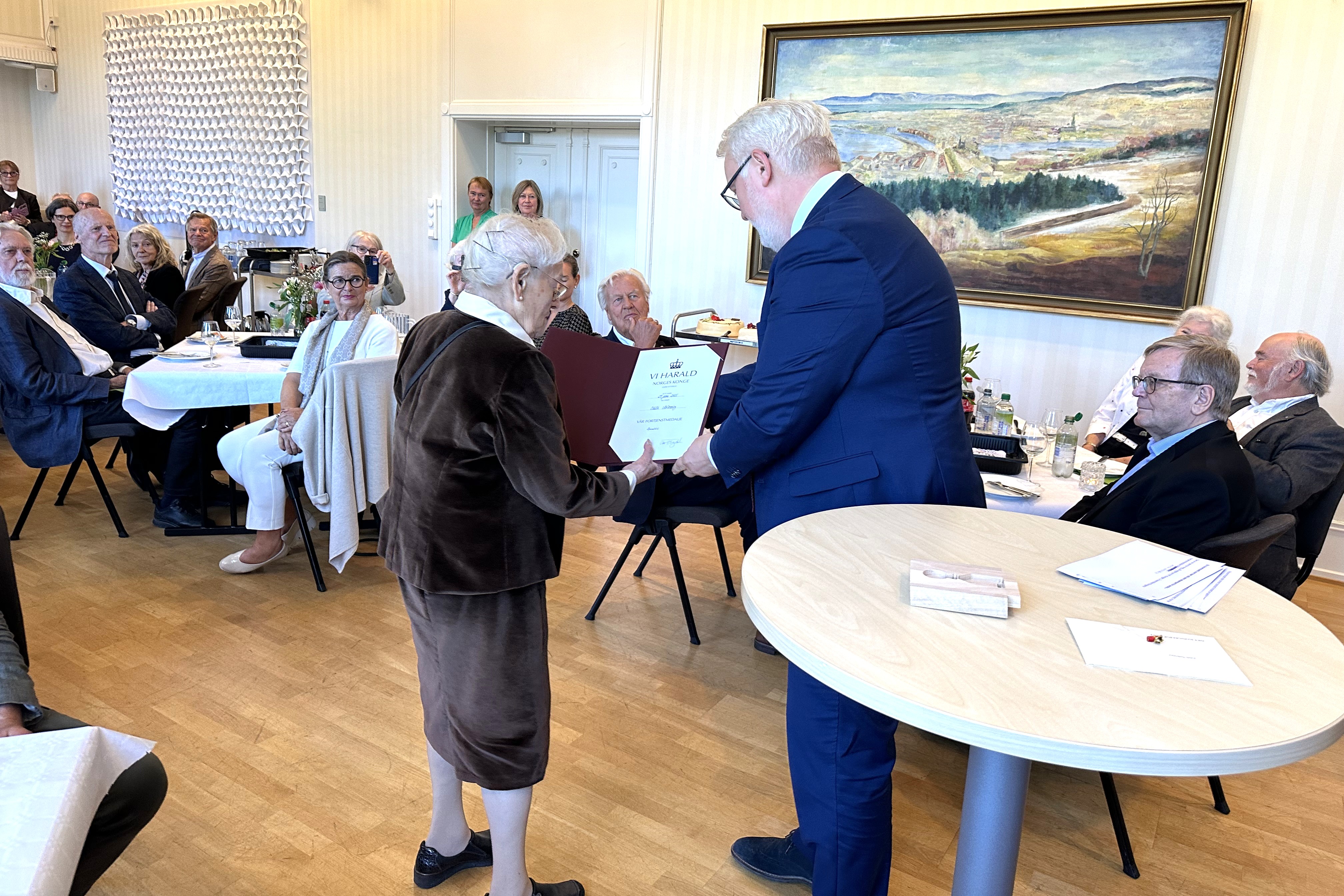 Edith Notowicz mottar Kongens Fortjenstmedalje fra statsforvalter Frank Jenssen under mottakelsen ved Trondheim rådhus. Foto: Statsforvalteren i Trøndelag.