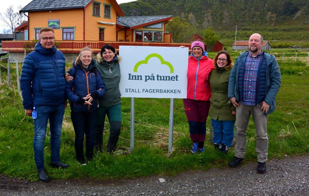 Foto: Statsforvalteren i Nordland. Bilde av personer fra Hadsel og i Vågan kommuner ved Inn på tunet-skilt på Stall Fagerbakken.