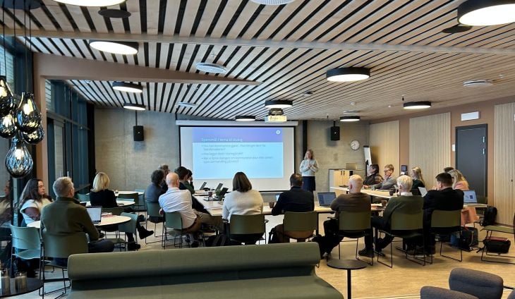 En kvinne som står fremfor en forsamling og snakker 