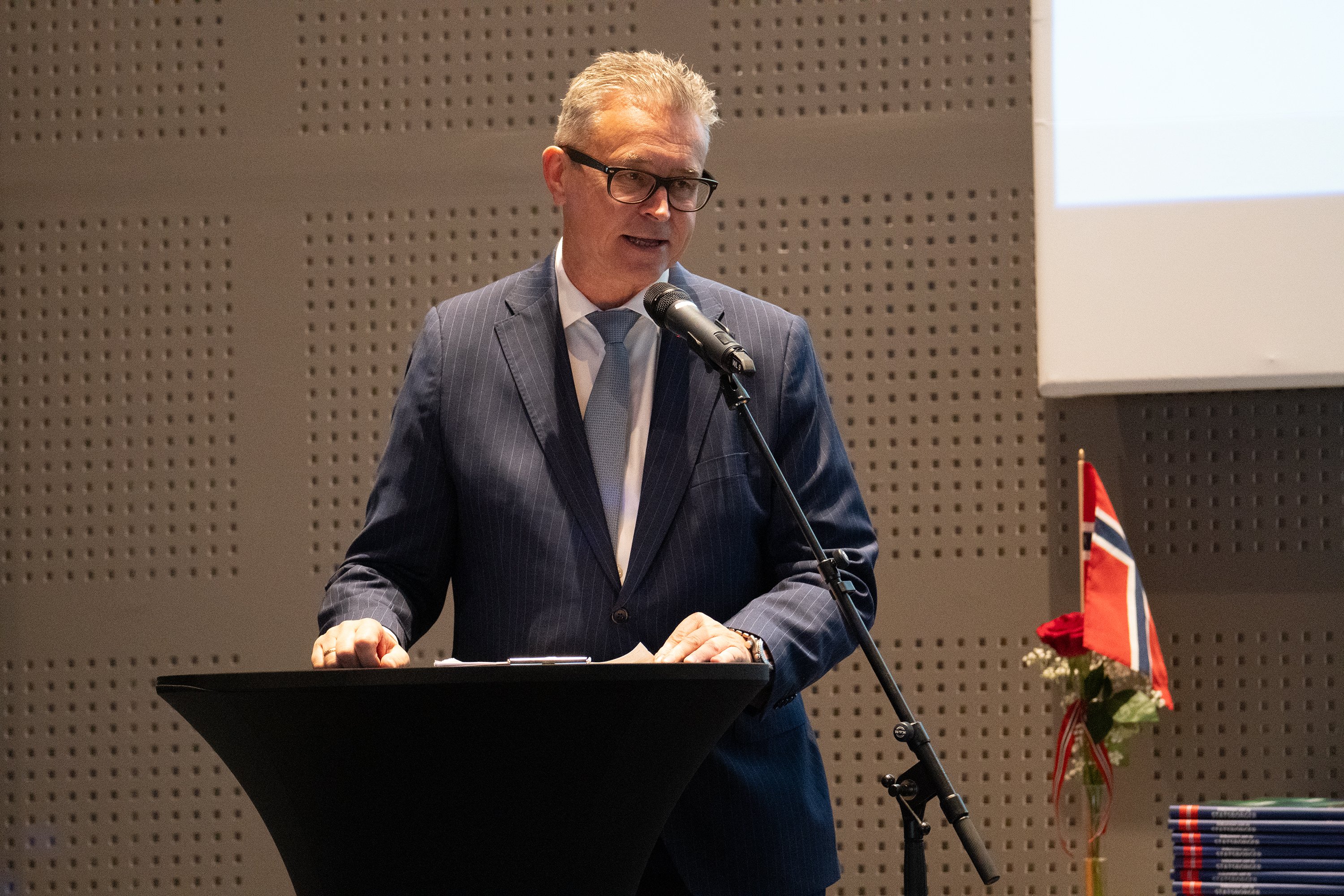 Bodø-ordfører Odd Emil Ingebrigtsen var en av ordførerne som var til stede og ønsket deltakerne velkommen som statsborgere i Nordland og Bodø. Mann i dress står bak en talerstol.