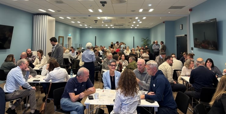 Forsamling med personar oppdelt i mindre grupper.