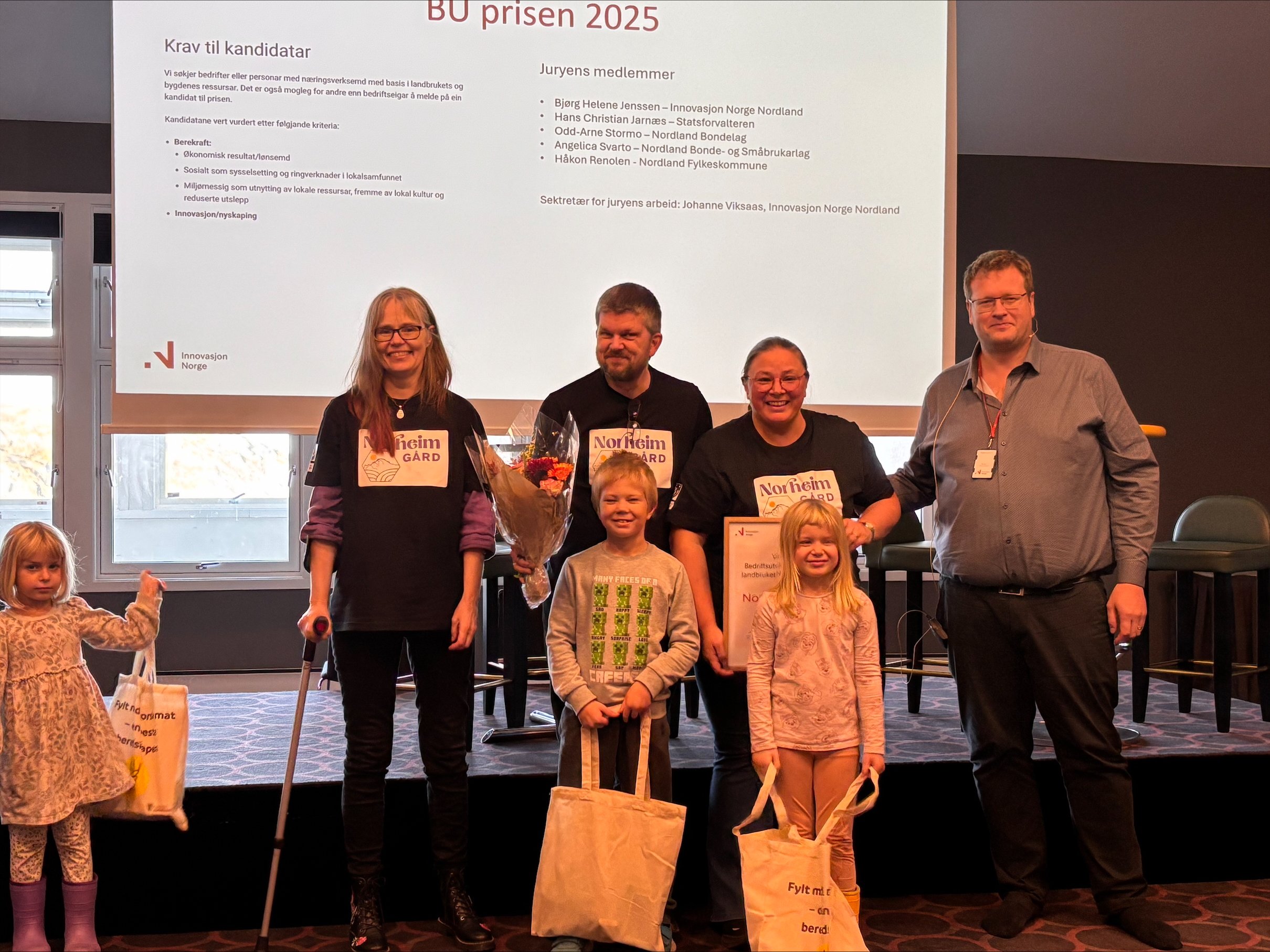 En gruppe mennesker står foran en scene.