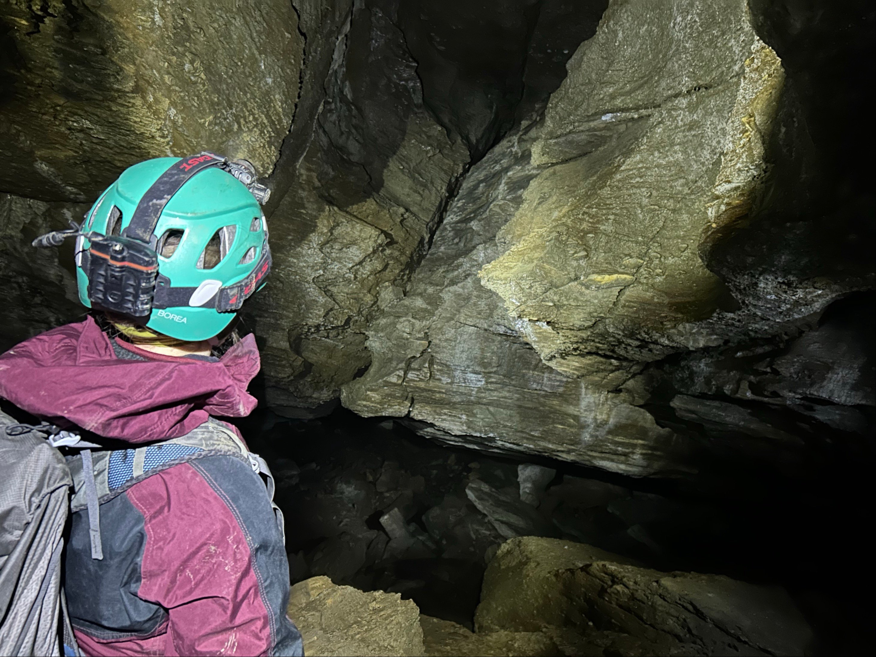 Eit bilete av ein person med hjelm som er inne i ei grotte.