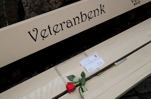 Bilde av en hvit benk som det står veteranbenk på. På benken ligger en rød rose