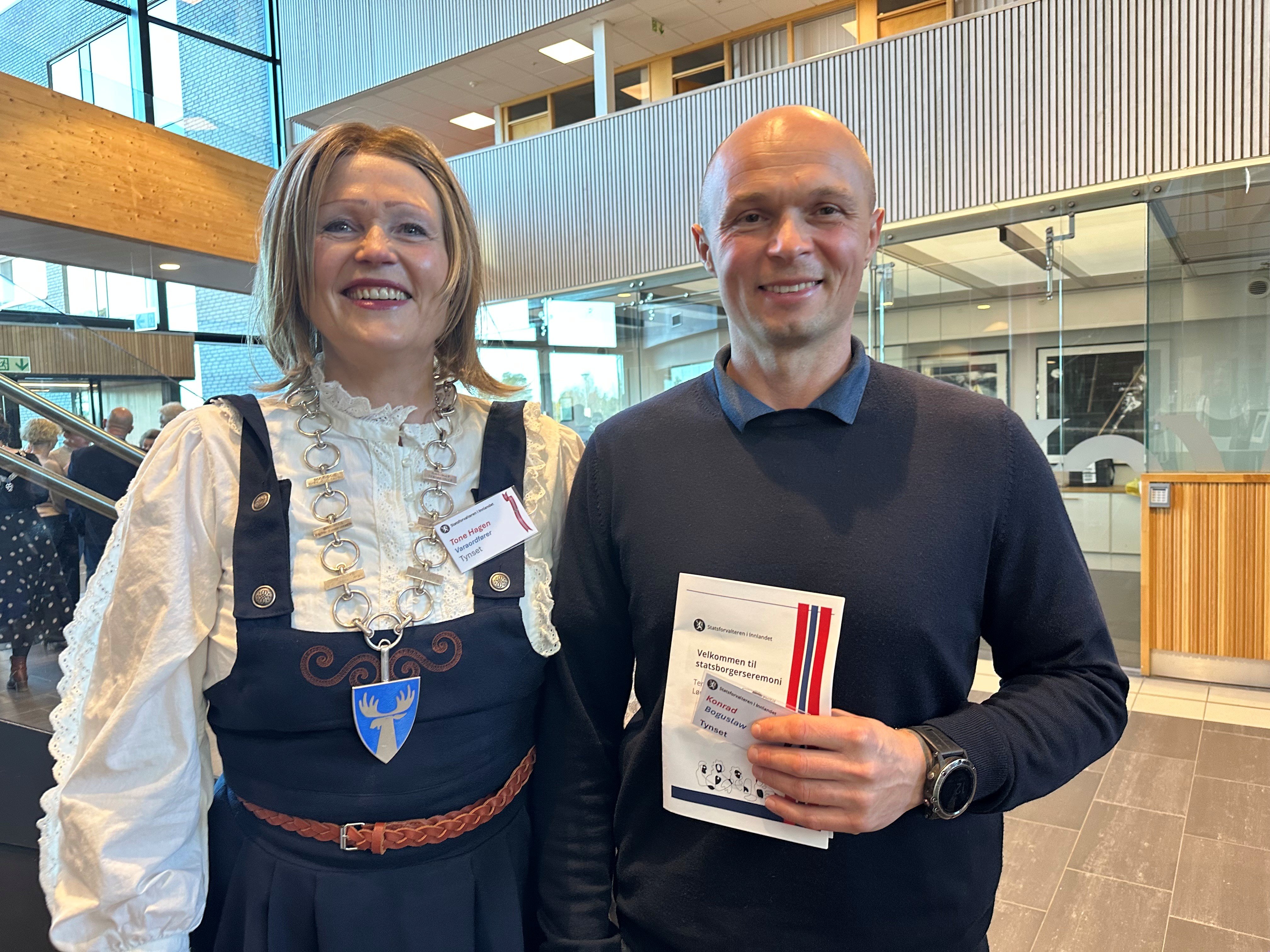 Festkledde deltagere: Konrad Boguslaw og varaordfører Tone Hagen fra Tynset under statsborgerseremoni i Terningen arena i Elverum.