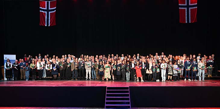 Alle de nye statsborgerne samlet på scenen i Håkons Hall. Foto: Statsforvalteren i Innlandet/Kristina Skamsar. Gruppebilde