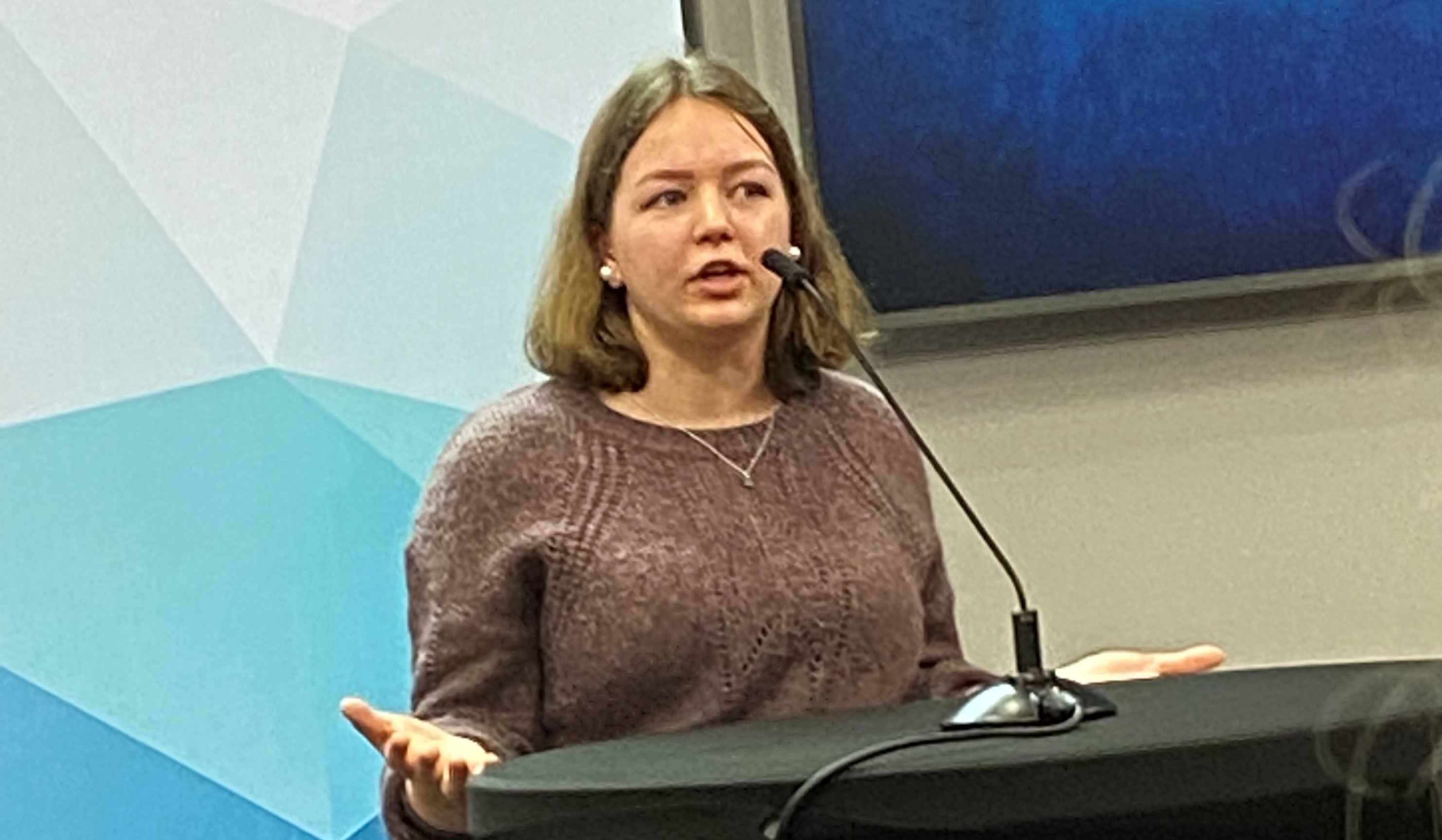 Vårin Dagsgard-Marstein står på talarstolen og held innlegg for blant anna barneombodet barne- og familieministeren. Foto: Eli Blakstad. Vårin Dagsgard-Marstein står på talarstolen og held innlegg for ei forsamling, blant anna barneombodet og barne- og familieministeren.
