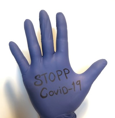 Lilla engangshanske med teksten "Stopp Covid-19"