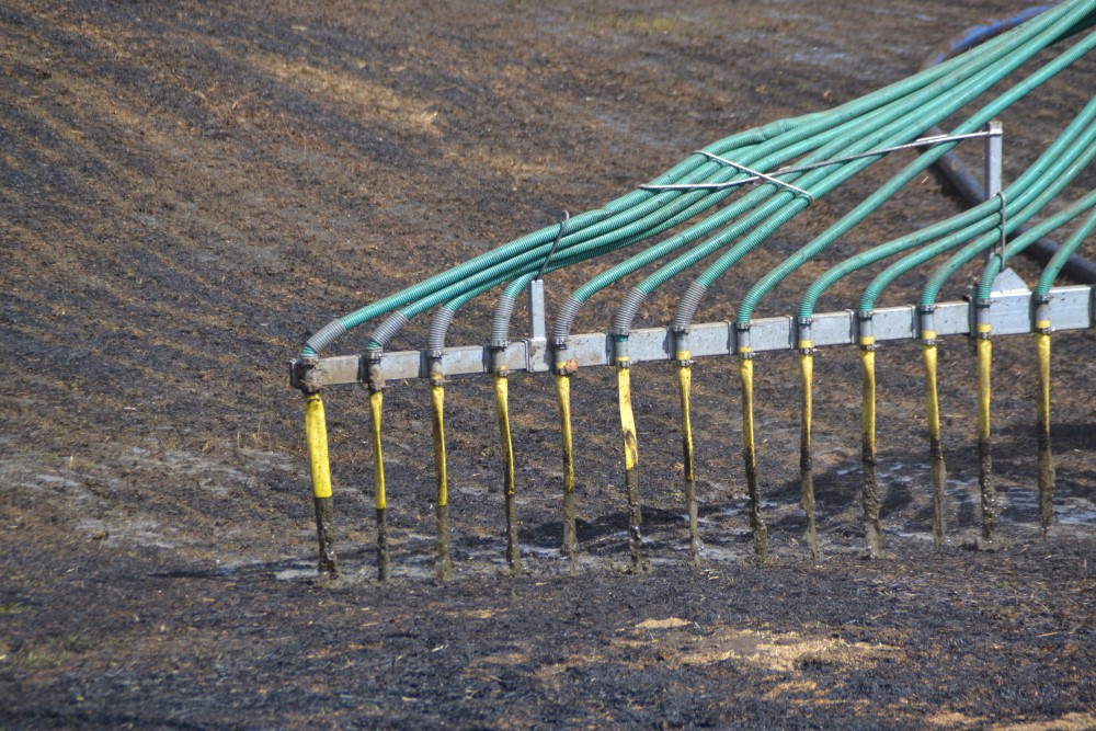 Nedlegging av husdyrgjødsel direkte på bakken gir bedre utnytting av næringsinnholdet og mindre utslipp av klimagasser. Foto: Karoline Finstad Vold. Nærbilde av dyser som legger ned husdyrgjødsel på jorde