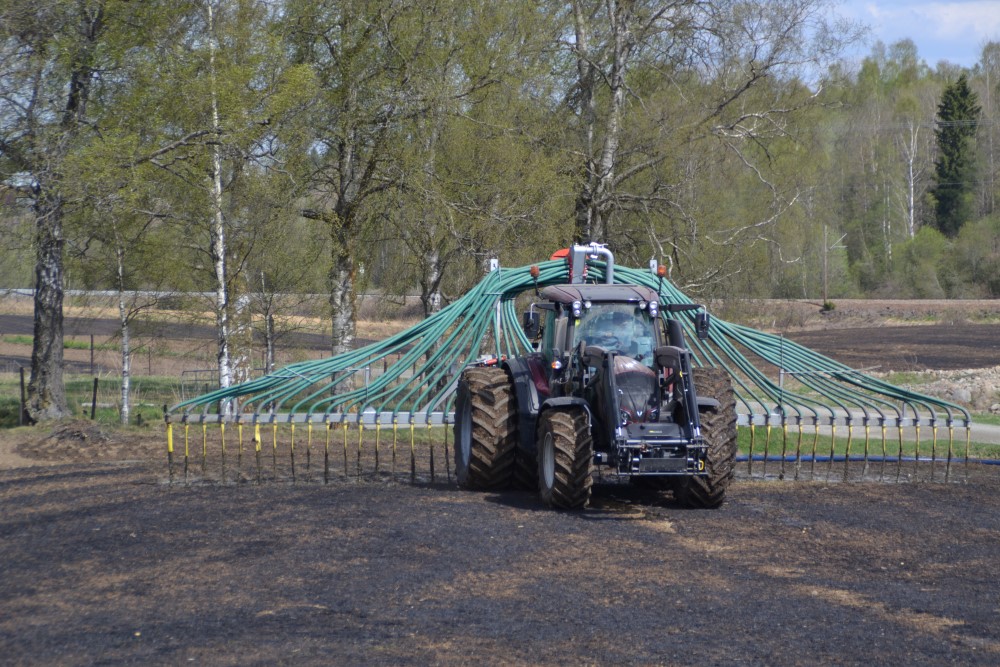 Traktor på jorde med påmontert utstyr for nedlegging av bløt husdyrgjødsel 