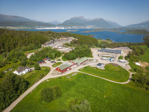 Gårdsanlegg for biogass hos Inge Hoemsnes Foto: Thing kommunikasjon as. Flyfoto eller dronebilde av ein gard med mange hus og biogasskum