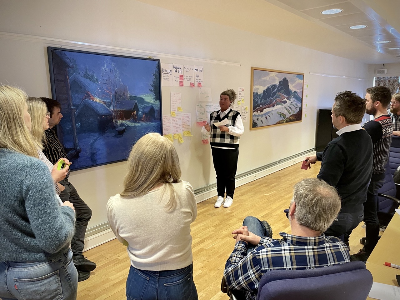 Deltakarane diskuterte idéar og draumar om utvikling med ekspertane og kvarandre. Her får Line Margrethe Svien frå Tyinlam attendemeldingar samstundes som ho inspirerer dei andre deltakarane. Foto: Lene Hovi / Lene Hovi. En dame som står og snakker til en gruppe mennesker.
