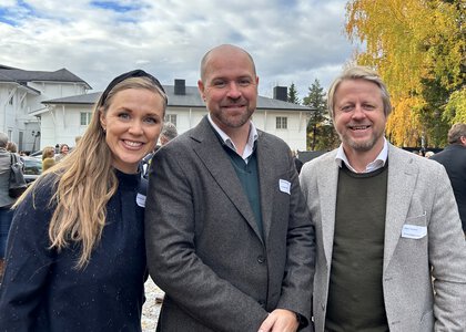 Fra venstre Inga Blæsterdalen (Statsforvalteren), prosjektleder Fredrik Holte Breien (Innlandet fylkeskommune) og Håkon Lauvålien (Innovasjon Norge). Foto: Leila Øvreseth. Tre mennesker, ei kvinne og to menn, ved siden av hverandre. Bildet er tatt utendørs. I bakgrunnen skimtes et hvitt hus og noen trær i høstfarger.