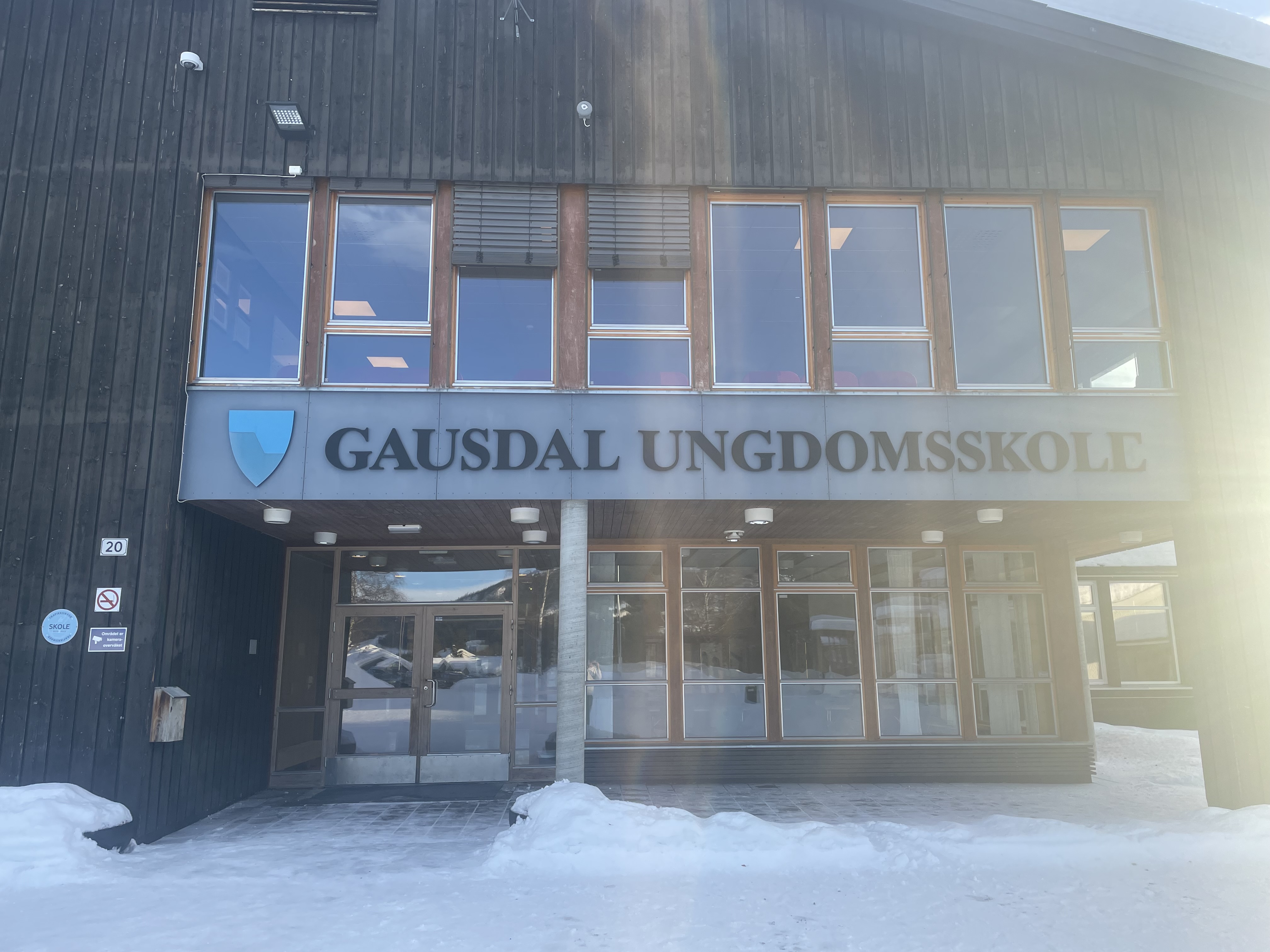 Gausdal ungdomsskole speiler seg i solen. Foto: Aslak Nordstoga Lilleland. Utenfor skole
