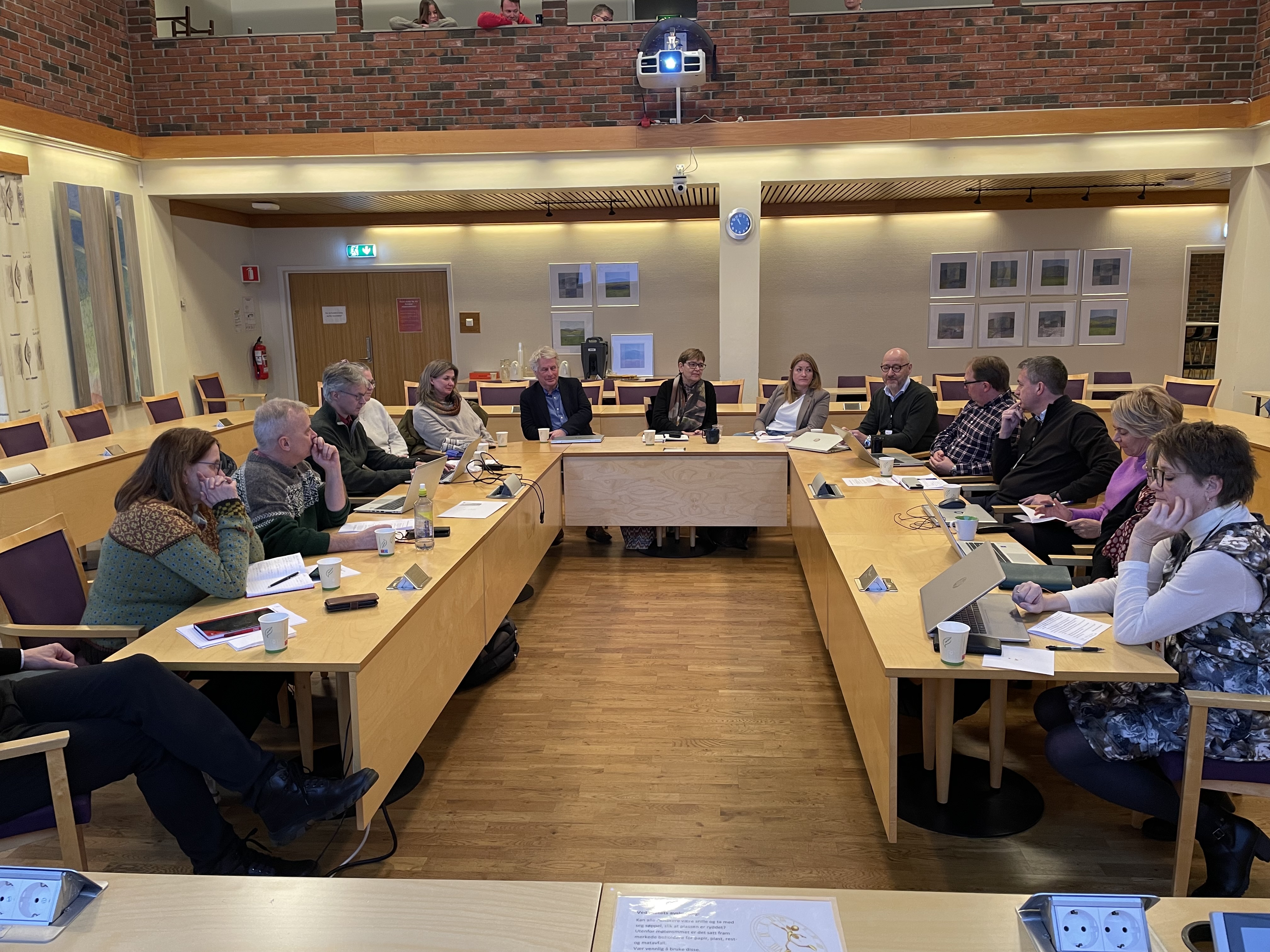 Diskusjon om fylkesbytte mellom statsforvalter og kommune. Foto: Aslak Nordstoga Lilleland. Folk sitter rundt et bord i et møterom