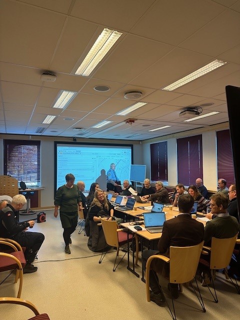 Kommunens kriseledelse Foto: Gro Taraldsen. Personer som sitter rundt et bord i et rom