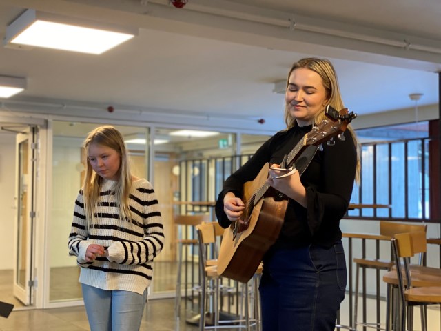 Dovringene Elise Ulheim synger og Martine Haugen spiller gitar for Statsforvalteren i Innlandet og vertskapet i Dovre kommune. Foto: Karianne Stordal / Statsforvalteren i Innlandet. Elise Ulheim synger og Martine Haugen spiller gitar.