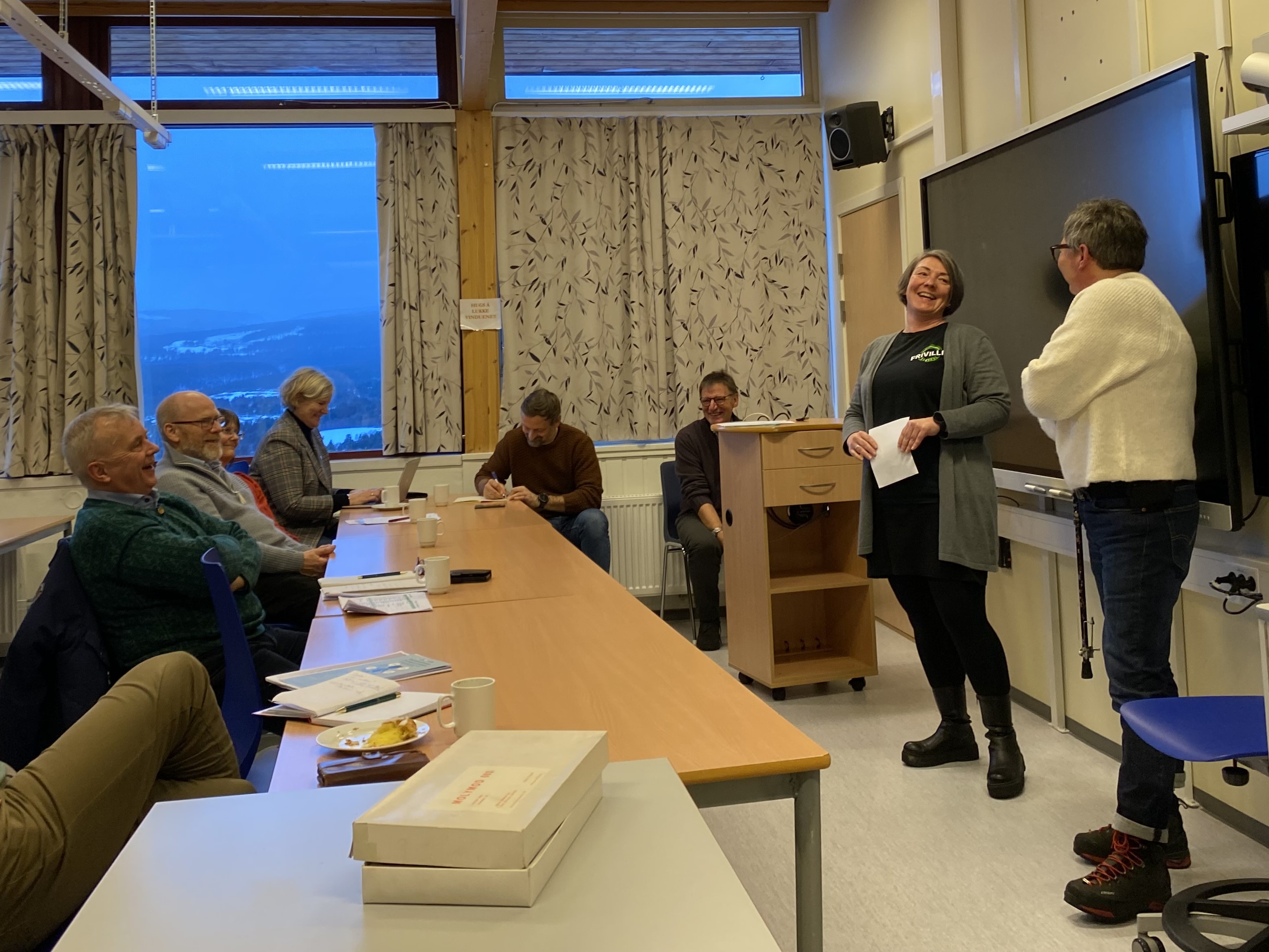 Anett Haugen og Linda Berntsen ved Frivilligsentralen i Dovre forteller om Seniorsurf med engasjement som smitter. Foto: Karianne Stordal / Statsforvalteren i Innlandet. Statsforvalteren i Innlandet, ordfører i Dovre og flere møter to ansatte på Frivilligsentralen som forteller om Seniorsurf.